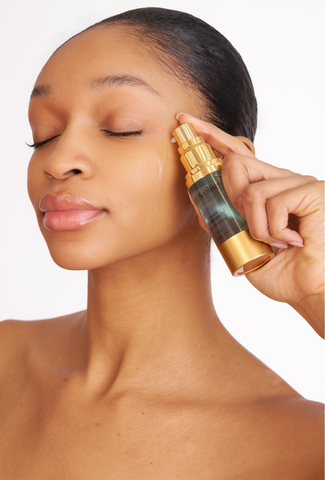 Woman applying a skincare product to her face with a dropper.